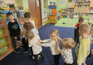 Dzieci ustawione w szeregu stoją przed chłopcem.