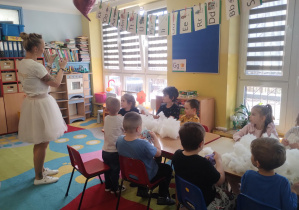 dzieci przy stolikach wykonują i ozdabiają króliki z materiału