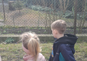 dzieci na spacerze szukają oznak wiosny