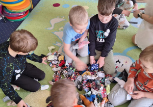 Dzieci wybierają ubranka dla swoich zajączków.