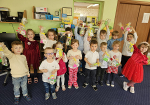 Dzieci prezentują swoje świąteczne prezenty.