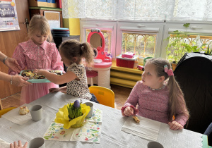 Dziewczynka częstuje dzieci babeczkami przygotowanymi wraz z mamą i siostrą.