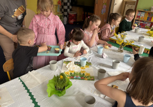 Dziewczynka częstuje dzieci babeczkami przygotowanymi wraz z mamą i siostrą.