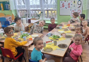 Dzieci siedzą przy stole.