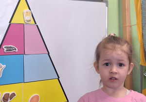 Dziewczynka układa piramidę zdrowego żywienia.