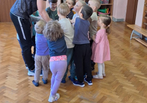 Dzieci wykonują ćwiczenia z piłką.