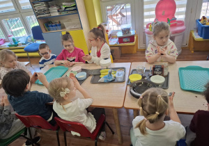 dzieci przygotowują podwieczorek z różnych produktów