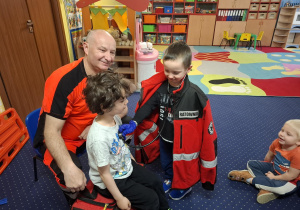 ratownik medyczny z wizytą u dzieci z grupy 2, dzieci poznają zawód ratownika medycznego, uczą się pierwszej pomocy