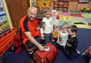 ratownik medyczny z wizytą u dzieci z grupy 2, dzieci poznają zawód ratownika medycznego, uczą się pierwszej pomocy
