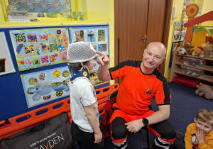 ratownik medyczny z wizytą u dzieci z grupy 2, dzieci poznają zawód ratownika medycznego, uczą się pierwszej pomocy