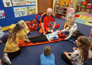 ratownik medyczny z wizytą u dzieci z grupy 2, dzieci poznają zawód ratownika medycznego, uczą się pierwszej pomocy