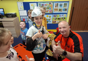 ratownik medyczny z wizytą u dzieci z grupy 2, dzieci poznają zawód ratownika medycznego, uczą się pierwszej pomocy