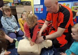 ratownik medyczny z wizytą u dzieci z grupy 2, dzieci poznają zawód ratownika medycznego, uczą się pierwszej pomocy