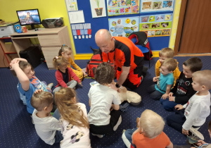 ratownik medyczny z wizytą u dzieci z grupy 2, dzieci poznają zawód ratownika medycznego, uczą się pierwszej pomocy