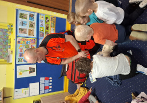 ratownik medyczny z wizytą u dzieci z grupy 2, dzieci poznają zawód ratownika medycznego, uczą się pierwszej pomocy