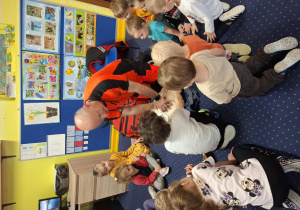 ratownik medyczny z wizytą u dzieci z grupy 2, dzieci poznają zawód ratownika medycznego, uczą się pierwszej pomocy