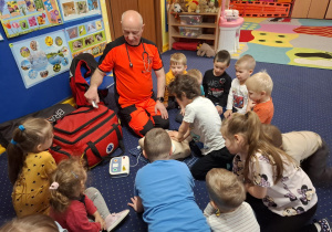 ratownik medyczny z wizytą u dzieci z grupy 2, dzieci poznają zawód ratownika medycznego, uczą się pierwszej pomocy