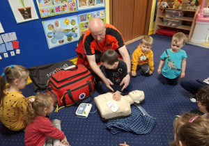 ratownik medyczny z wizytą u dzieci z grupy 2, dzieci poznają zawód ratownika medycznego, uczą się pierwszej pomocy