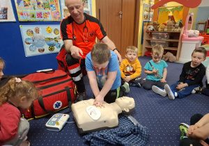ratownik medyczny z wizytą u dzieci z grupy 2, dzieci poznają zawód ratownika medycznego, uczą się pierwszej pomocy