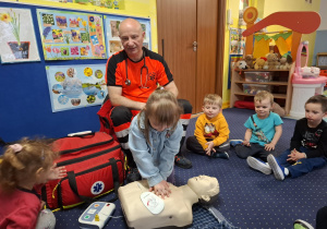 ratownik medyczny z wizytą u dzieci z grupy 2, dzieci poznają zawód ratownika medycznego, uczą się pierwszej pomocy