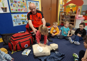 ratownik medyczny z wizytą u dzieci z grupy 2, dzieci poznają zawód ratownika medycznego, uczą się pierwszej pomocy