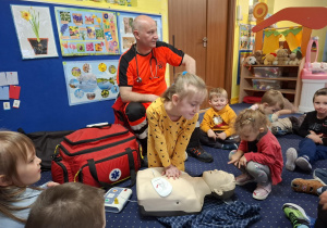 ratownik medyczny z wizytą u dzieci z grupy 2, dzieci poznają zawód ratownika medycznego, uczą się pierwszej pomocy