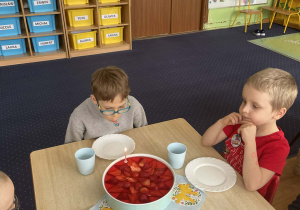 Chłopiec zdmuchuje świeczkę na cieście.