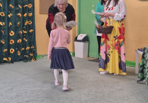 Dziewczynka odbiera nagrodę za udział w konkursie.