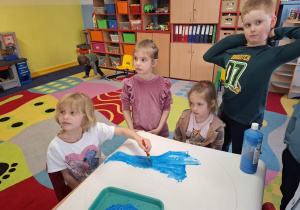 dzieci malują plakat na dzień ziemi