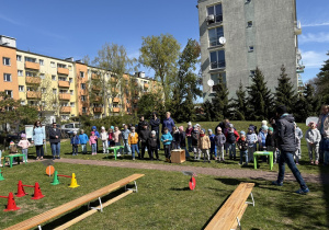 w ogródku przedszkolnym odbywają się sportowe konkurencje, w których uczestniczą dzieci