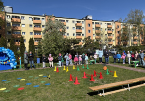 w ogródku przedszkolnym odbywają się sportowe konkurencje, w których uczestniczą dzieci