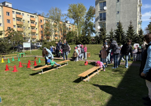 w ogródku przedszkolnym odbywają się sportowe konkurencje, w których uczestniczą dzieci