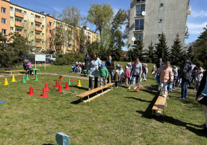w ogródku przedszkolnym odbywają się sportowe konkurencje, w których uczestniczą dzieci
