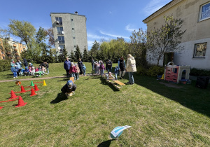 w ogródku przedszkolnym odbywają się sportowe konkurencje, w których uczestniczą dzieci