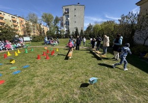 w ogródku przedszkolnym odbywają się sportowe konkurencje, w których uczestniczą dzieci