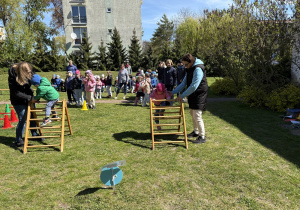 w ogródku przedszkolnym odbywają się sportowe konkurencje, w których uczestniczą dzieci