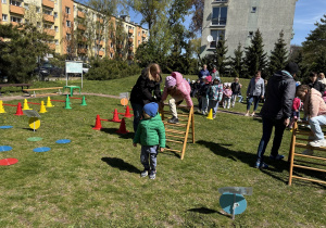 w ogródku przedszkolnym odbywają się sportowe konkurencje, w których uczestniczą dzieci