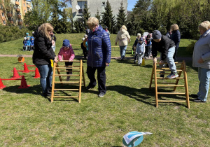 w ogródku przedszkolnym odbywają się sportowe konkurencje, w których uczestniczą dzieci