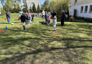 w ogródku przedszkolnym odbywają się sportowe konkurencje, w których uczestniczą dzieci