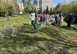 w ogródku przedszkolnym odbywają się sportowe konkurencje, w których uczestniczą dzieci