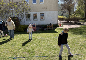 w ogródku przedszkolnym odbywają się sportowe konkurencje, w których uczestniczą dzieci
