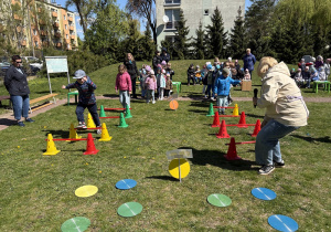 w ogródku przedszkolnym odbywają się sportowe konkurencje, w których uczestniczą dzieci