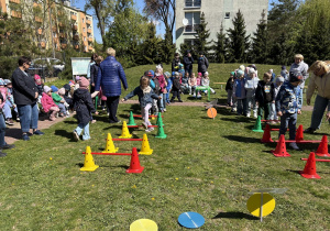 w ogródku przedszkolnym odbywają się sportowe konkurencje, w których uczestniczą dzieci