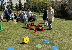 w ogródku przedszkolnym odbywają się sportowe konkurencje, w których uczestniczą dzieci