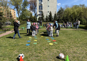 w ogródku przedszkolnym odbywają się sportowe konkurencje, w których uczestniczą dzieci