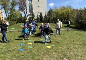 w ogródku przedszkolnym odbywają się sportowe konkurencje, w których uczestniczą dzieci