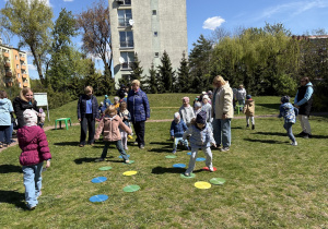 w ogródku przedszkolnym odbywają się sportowe konkurencje, w których uczestniczą dzieci