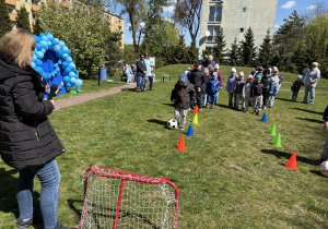 w ogródku przedszkolnym odbywają się sportowe konkurencje, w których uczestniczą dzieci