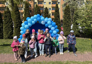 zdjęcie grupy dzieci na tle girlandy zrobionej z niebieskich balonów, na tablicy napis Niebieskie Igrzyska