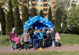 zdjęcie grupy dzieci na tle girlandy zrobionej z niebieskich balonów, na tablicy napis Niebieskie Igrzyska